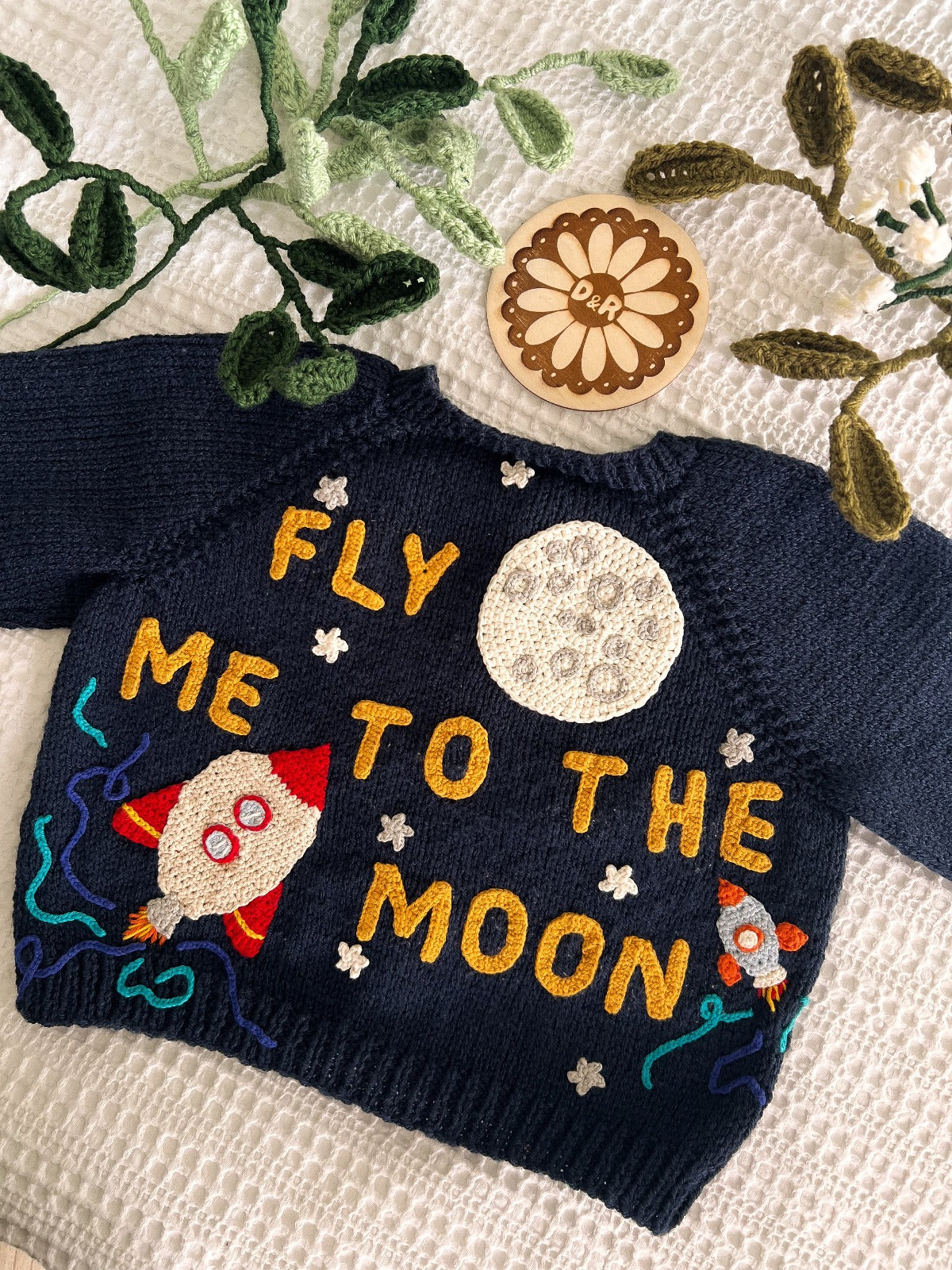 Handknitted cardigan with the words fly me to the moon